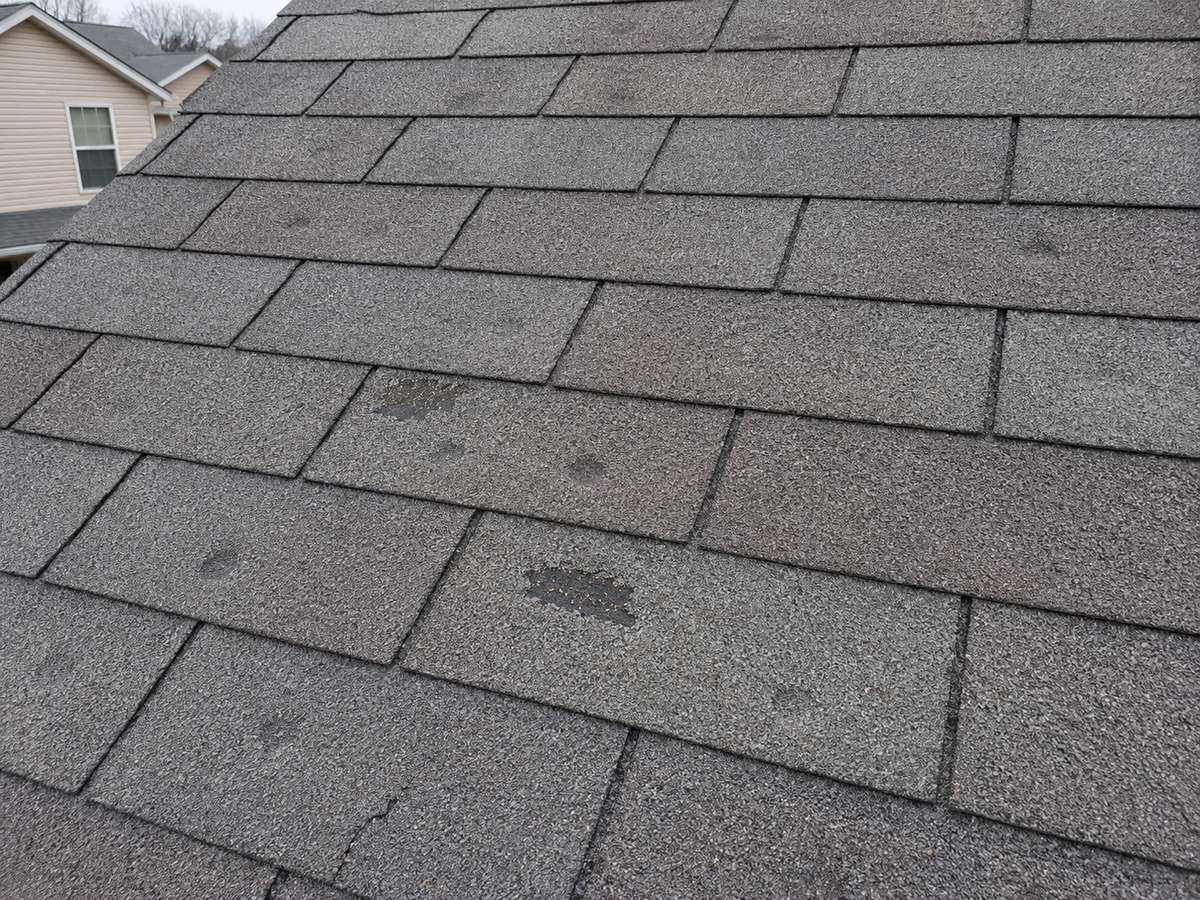 Close-up of hail damage on an asphalt shingle roof in Wisconsin