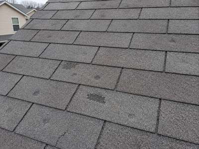 Close-up of hail damage on an asphalt shingle roof in Wisconsin