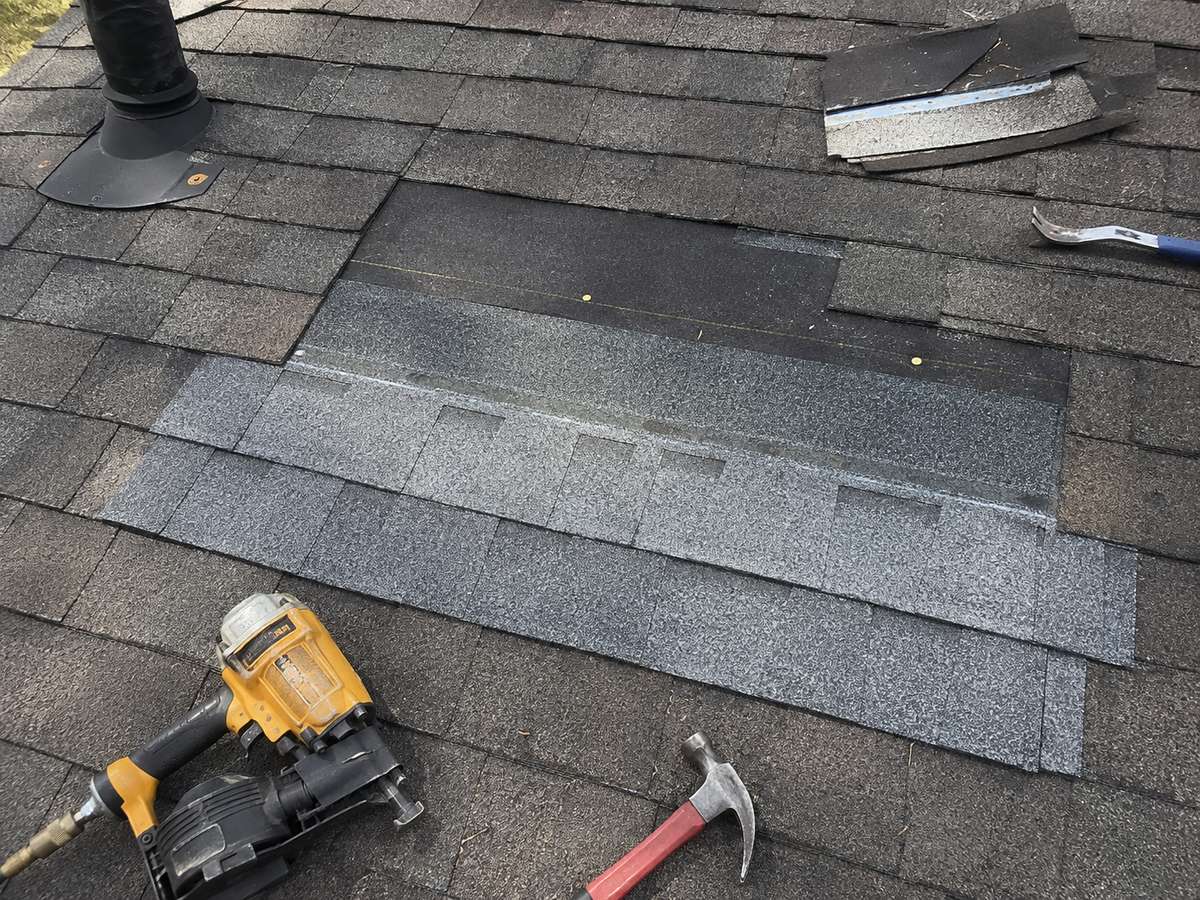 A roofer repairing asphalt shingles on a home in Milwaukee